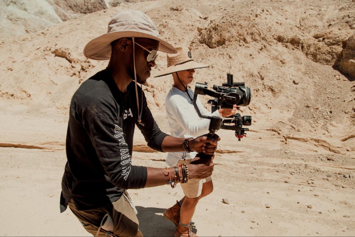 Juan Garcia and Jon Aragon each film with a camera in the desert. 