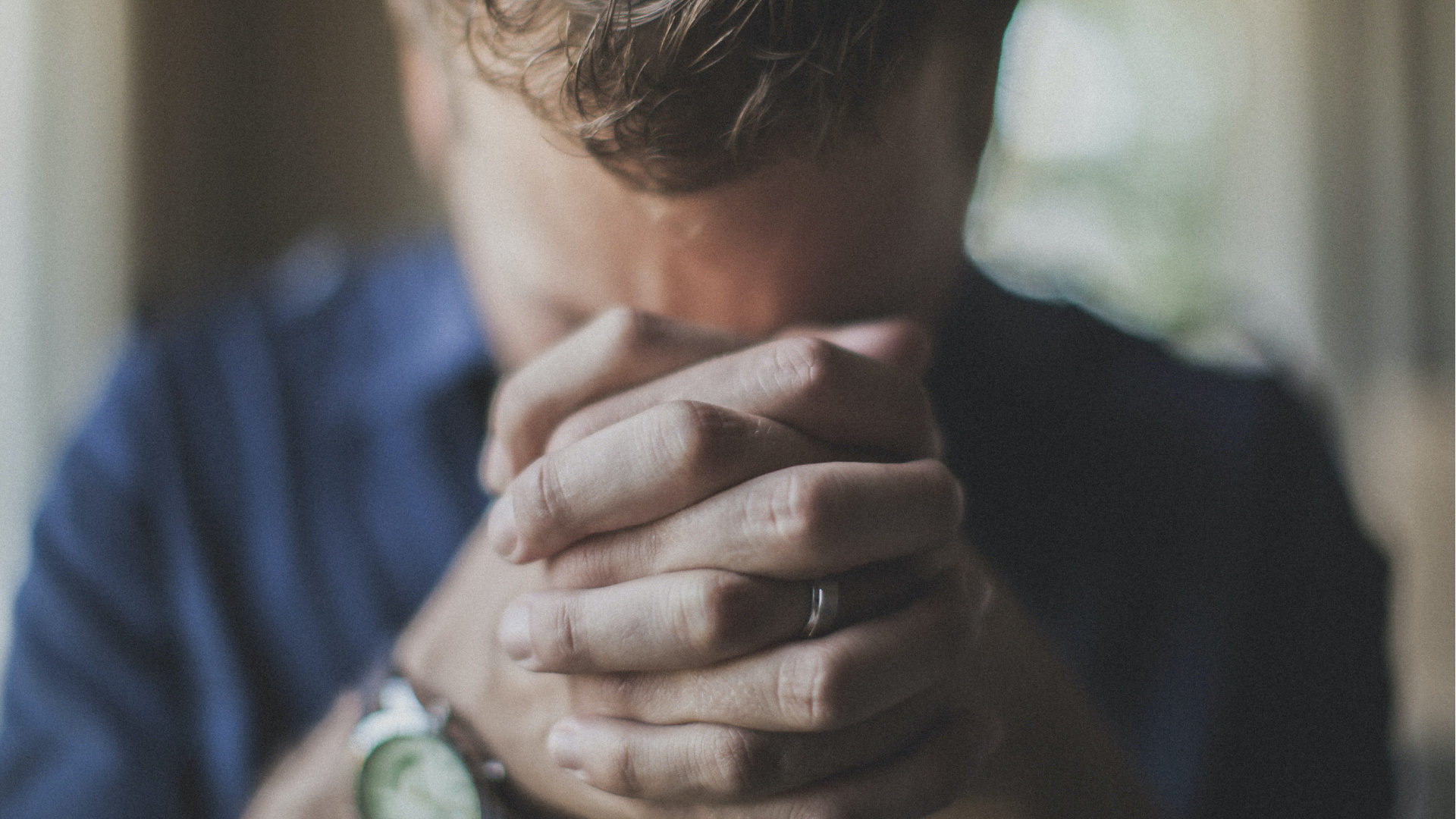 Man praying with hands folded