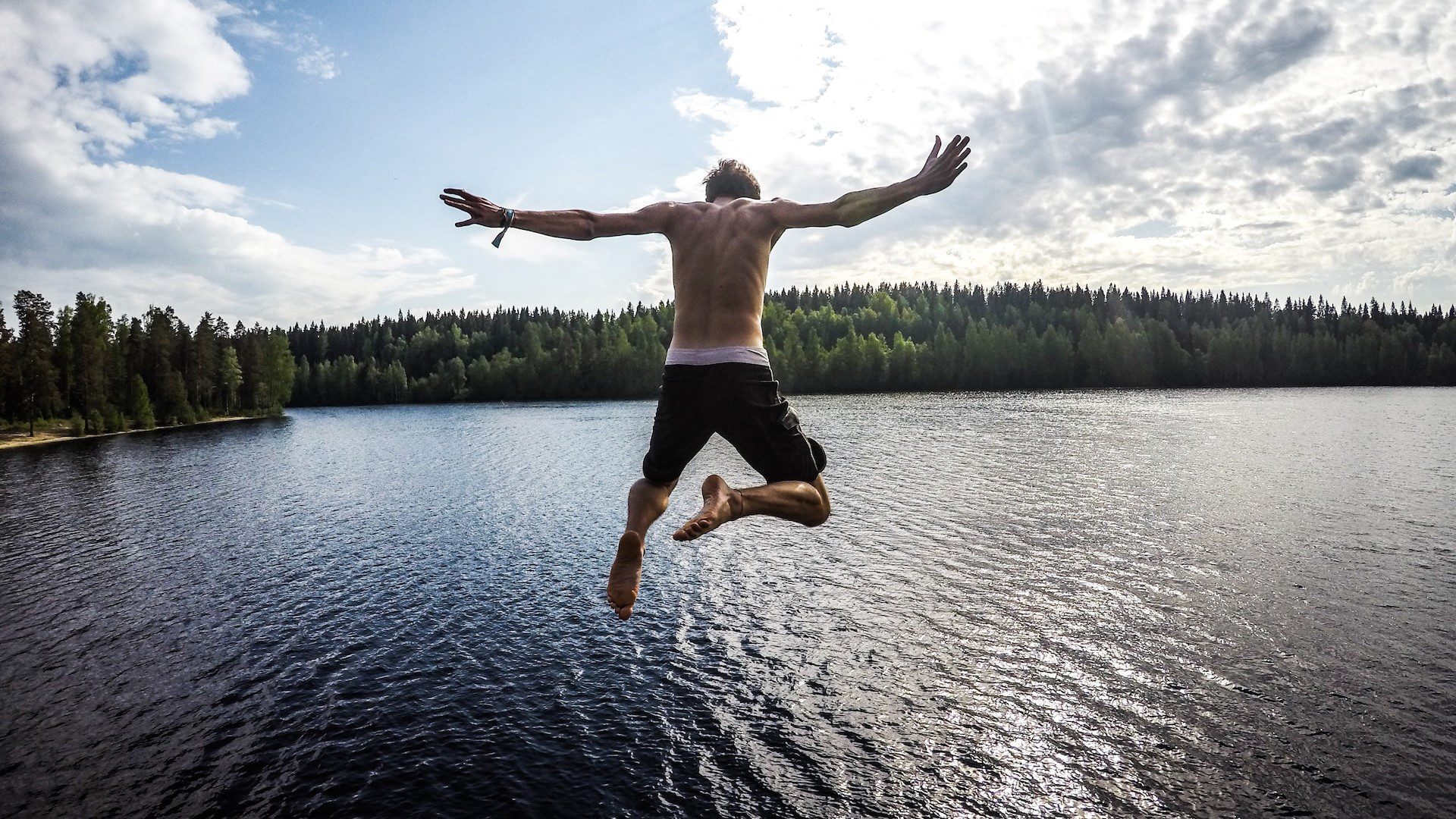man jumping into a lake