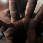 African child holding up hand to the camera - feeling of fear or insecurity