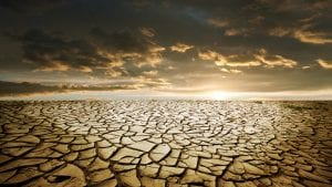 Blessings and Curses - Dry, cracked land under and sky that promises rain