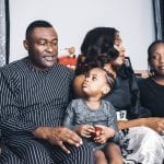 Disciple your teens - African parents and kids on a sofa together looking at each other intently