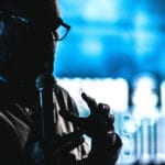 Women Don't Preach at our church - image of an African man preaching on a blue background