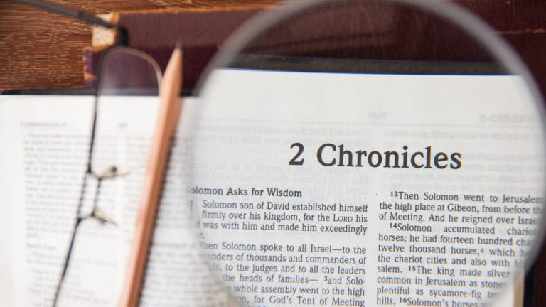 Does 2 Chronicles 7:14 explain COVID-19? Magnifying glass over 2 Chronicles page in Bible