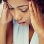 I've had an abortion - can God forgive me? African Woman with head in hands looking down