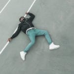 Floored by personal sin - young African man lying on tarmac