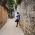 Confess your sins - it's critical - African man leaning against ancient wall alone