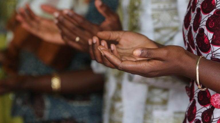 Corporate Confession? Congregants in an African church with their hands out to receive blessing