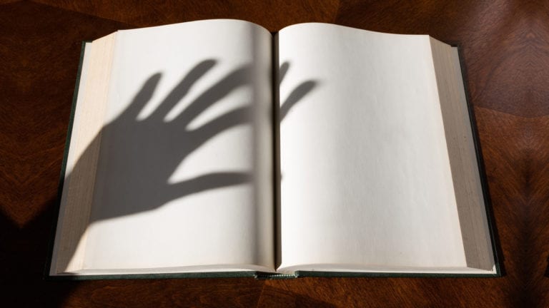 When deliverance goes wrong - unbiblical exorcism - a hand shadow over a blank bible