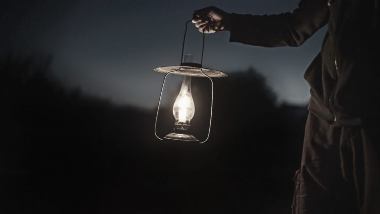 Spiritual Powers, witchcraft and christianity in Africa - a man holding a lantern in the darkness