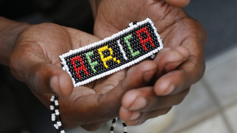 African culture & doing Church - Beaded Africa held in hands of African person