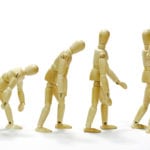 How do I grow spiritually? Wooden man going from slouching to standing up joyfully