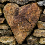 Biblical heart of a pastor - A rock in a heart shape surrounded by many other rocks.