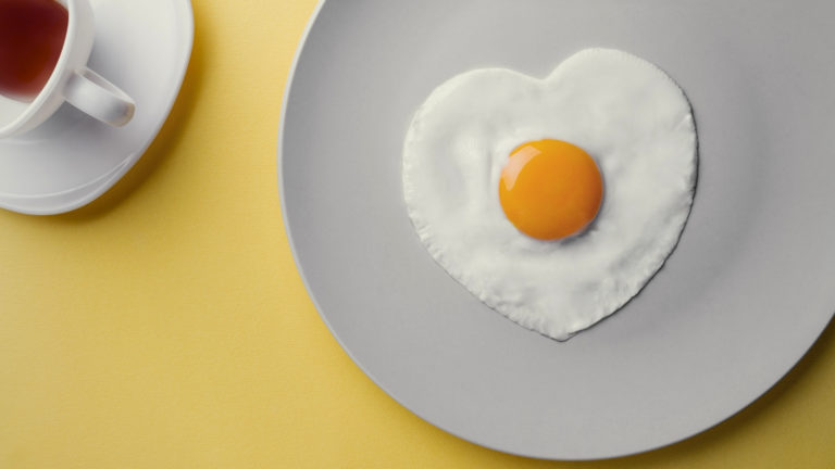 Shaped by grace - a fried egg in the shame of a heart on a plain plate