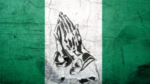 Conflict in Nigeria - Nigerian flag with praying hands on it.