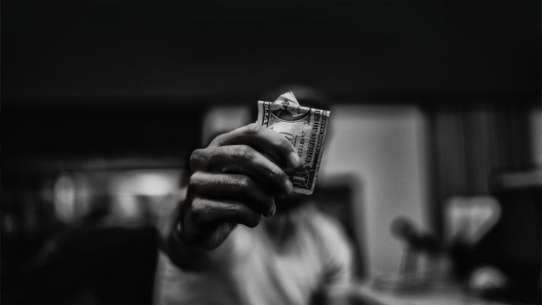 Corruption - A man handing a dollar bill over.