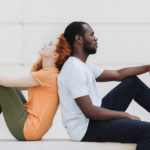 Interracial Relationships - Guy and girl sitting back to back.