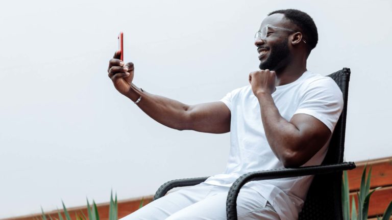 Influencers cant replace pastors - A guy sitting on a chair taking a video of himself with his phone