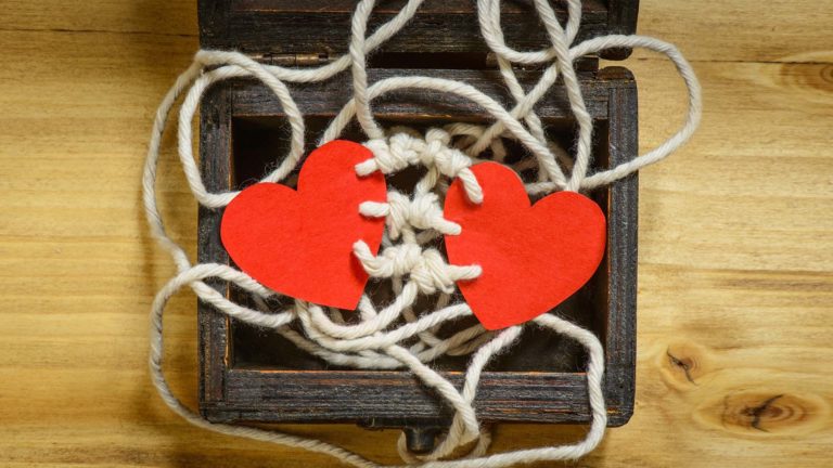 Gospel Reconciliation - An open wooden box with two paper red hearts in, attached together with strings.