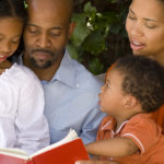Family Devotions - A family sitting together reading a book.