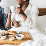 The Perfect weekend - A couple sitting in bed eating breakfast