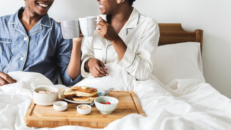 The Perfect weekend - A couple sitting in bed eating breakfast