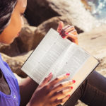 Discernment - A woman reading a bible out in nature