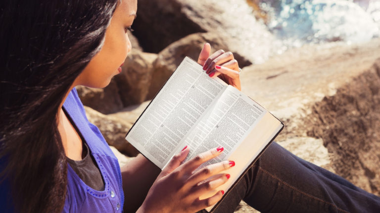 Discernment - A woman reading a bible out in nature