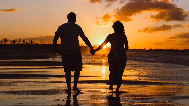 The bible on women - A couple holding hands on the beach