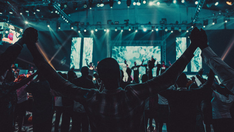 Miracles and discernment - People standing in church with hands raised