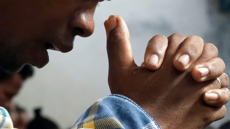 Biblical Prayer - A person praying, hands folded