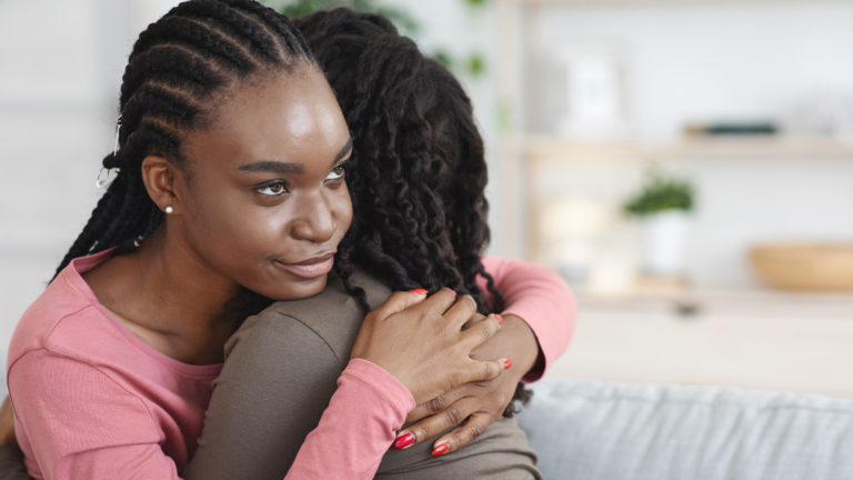 Envy - A girl hugging her friend with an envious look on her face