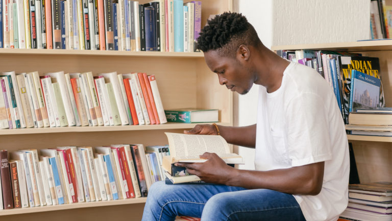 Church History - A guy reading a book in the library