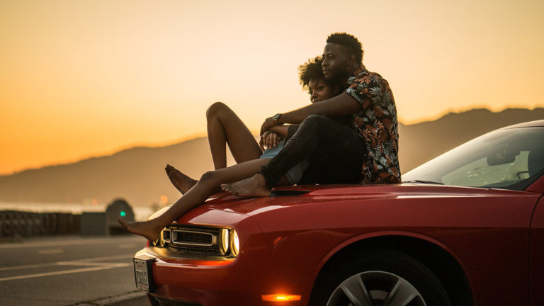 Sex - A couple sitting on a car watching sunset