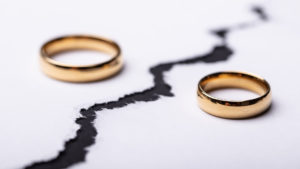 Sexual sin and marriage - Two wedding rings on paper and paper is torn apart