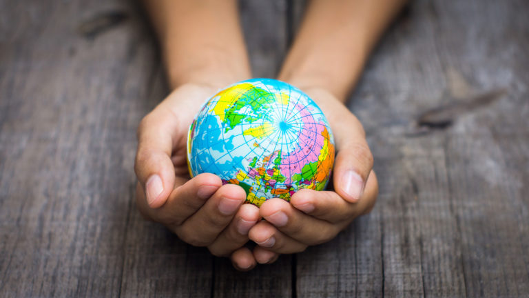 Missions - A woman holding a small earth globe in her hands