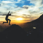 God's commandments - A person jumping over hills with sunshine in background