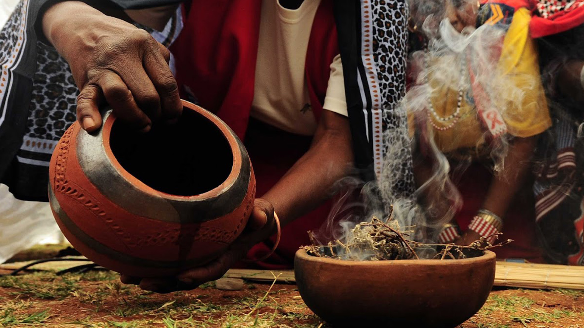 Ancestral Worship – A woman with a bowl in her hand pouring contents into a burning bowl of incense.