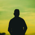 Rejection – A person standing by alone in nature looking out to the horizon
