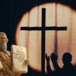 Law and Grace – Moses holding 2 tables of stones with written law and another person standing under the cross