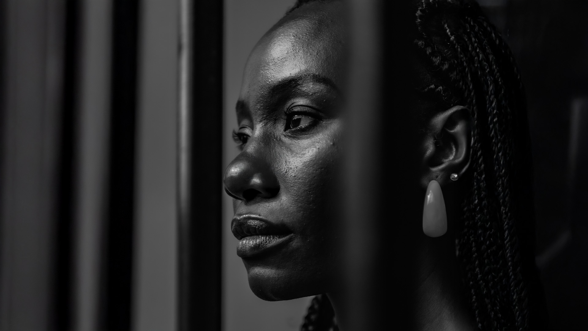 Singleness – A woman standing behind bars looking out into the distance