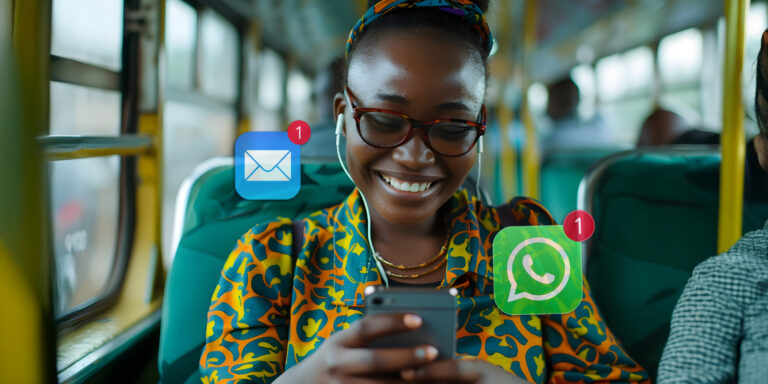 Never miss an article – A woman sitting in the bus with her phone, looking at the screen and smiling.