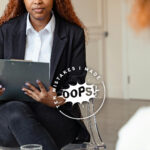 Biblical Counselor – A woman sitting on a chair with a book and pen, sitting opposite another woman.